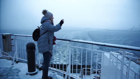 woman on a winter ferry ride in snowy weather