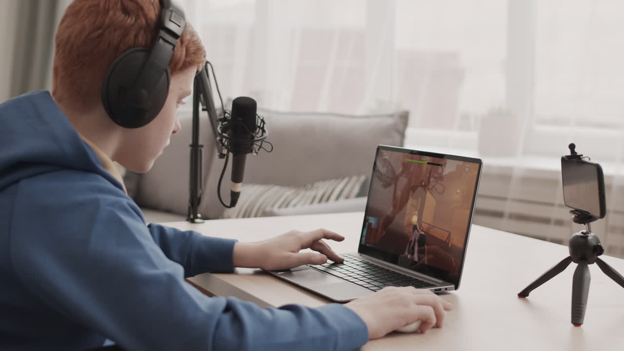 Teen gamer playing video game on laptop