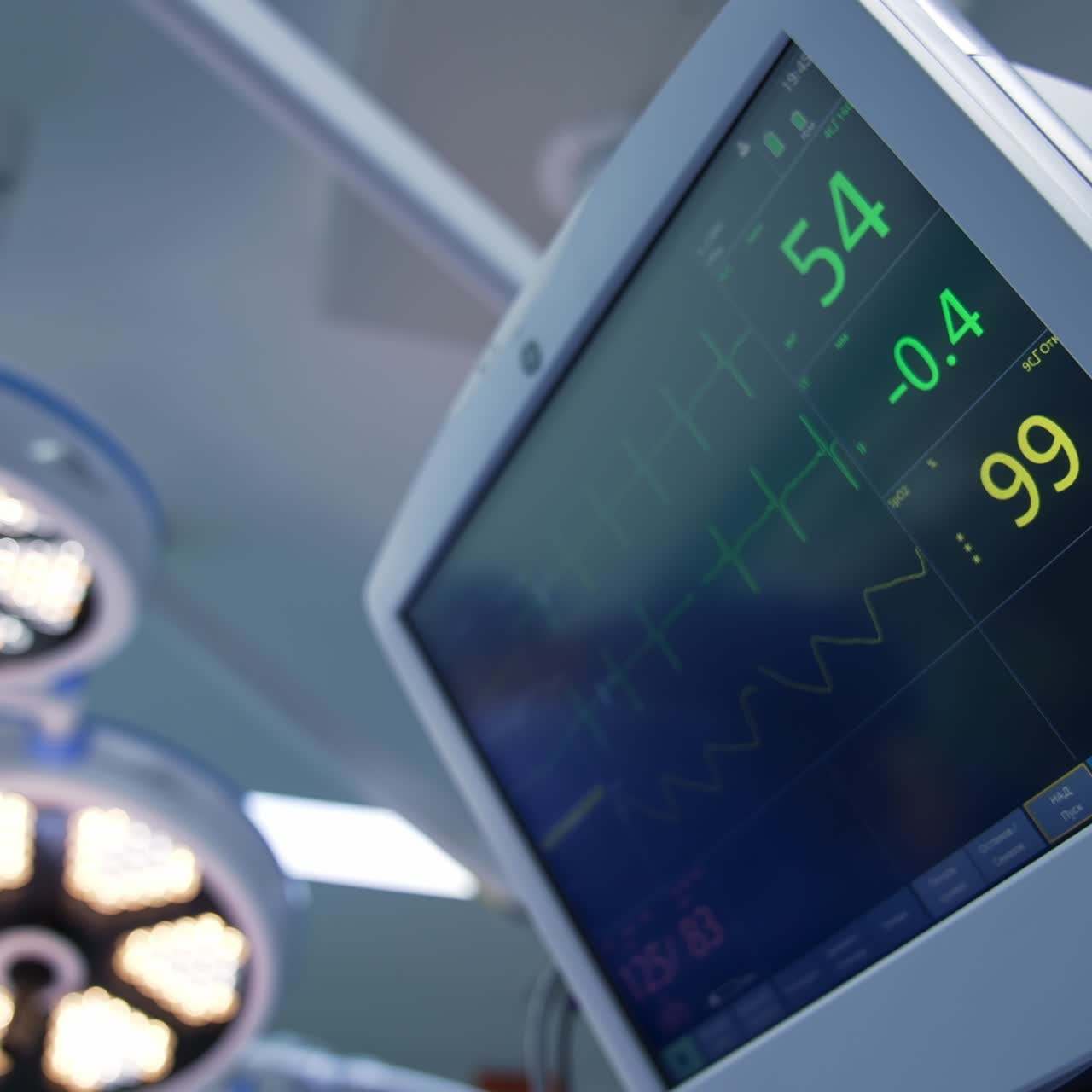 Vital signs of a patient on the screen in surgery room. Big lamps working in the operational theatre during operation