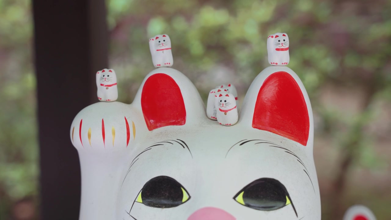 Maneki Neko -onnenkissapatsaan pää Gotokuji-temppelissä Tokiossa, Japanissa, esitellen yhden maan kuuluisimmista onnen, vaurauden ja perinteisen japanilaisen kulttuurin symboleista