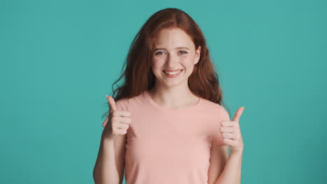 Redheaded-girl-looking-at-camera-on-turquoise-background.