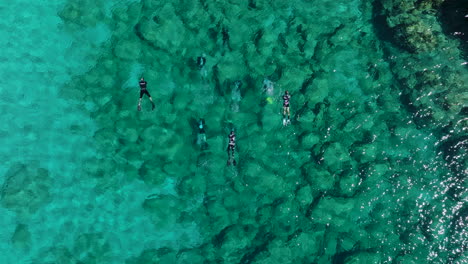 snorkelers and scuba divers in crystal clear waters of rhodes, greece