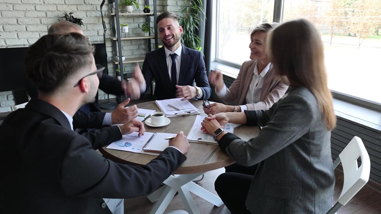 Equipe de Negócios Comemorando o Sucesso Durante uma Reunião em um Escritório Moderno