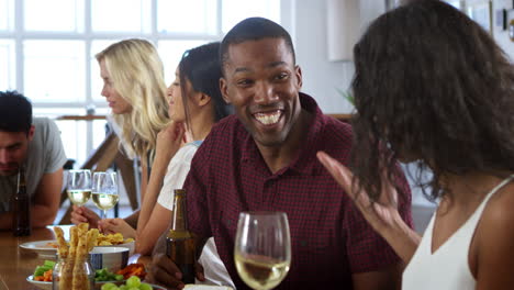group of friends enjoying dinner party at home together
