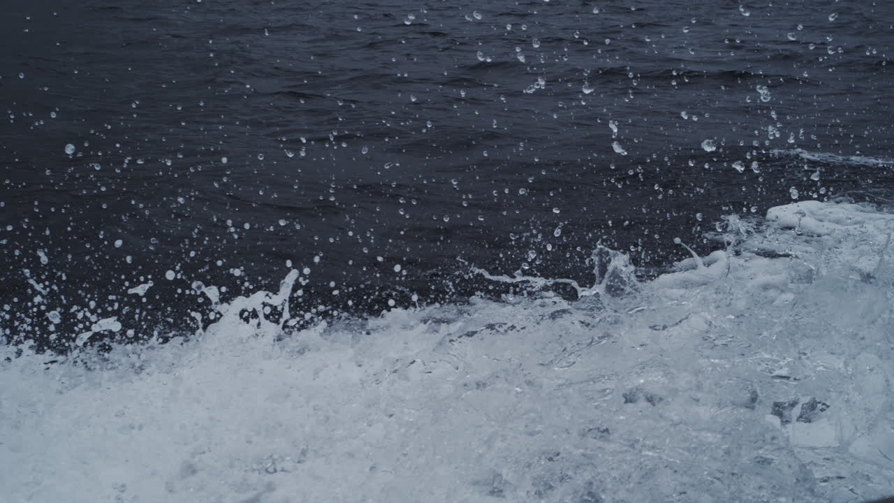Water splash and flies backward in slow motion with misty droplets, fluid liquid