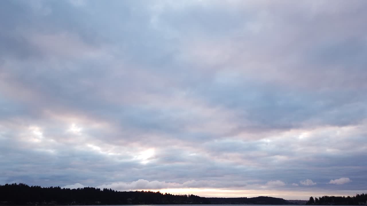 Slow zoom out hyperlapse of crisscrossing clouds over Puget sound and Tacoma Washington. slow pan left