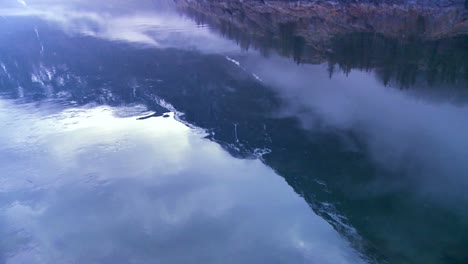 Panning-shot-along-the-water-of-a-fjord-in-fog-in-Norway