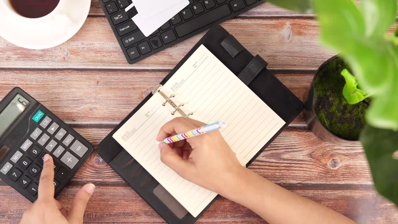 Person taking notes and calculating at a desk