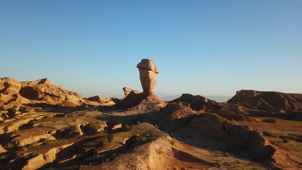 volar alrededor de un pilar de erosión de viento formación de acantilado de roca de piedra en el desierto de irán hora de puesta de sol temporada de verano en irán frontera de los eau paisaje natural maravilloso paisaje de fondo vista de bucle de imágenes