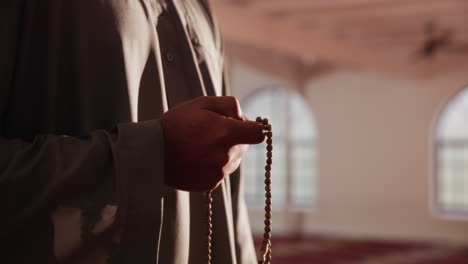 muslim man with prayer beads in mosque