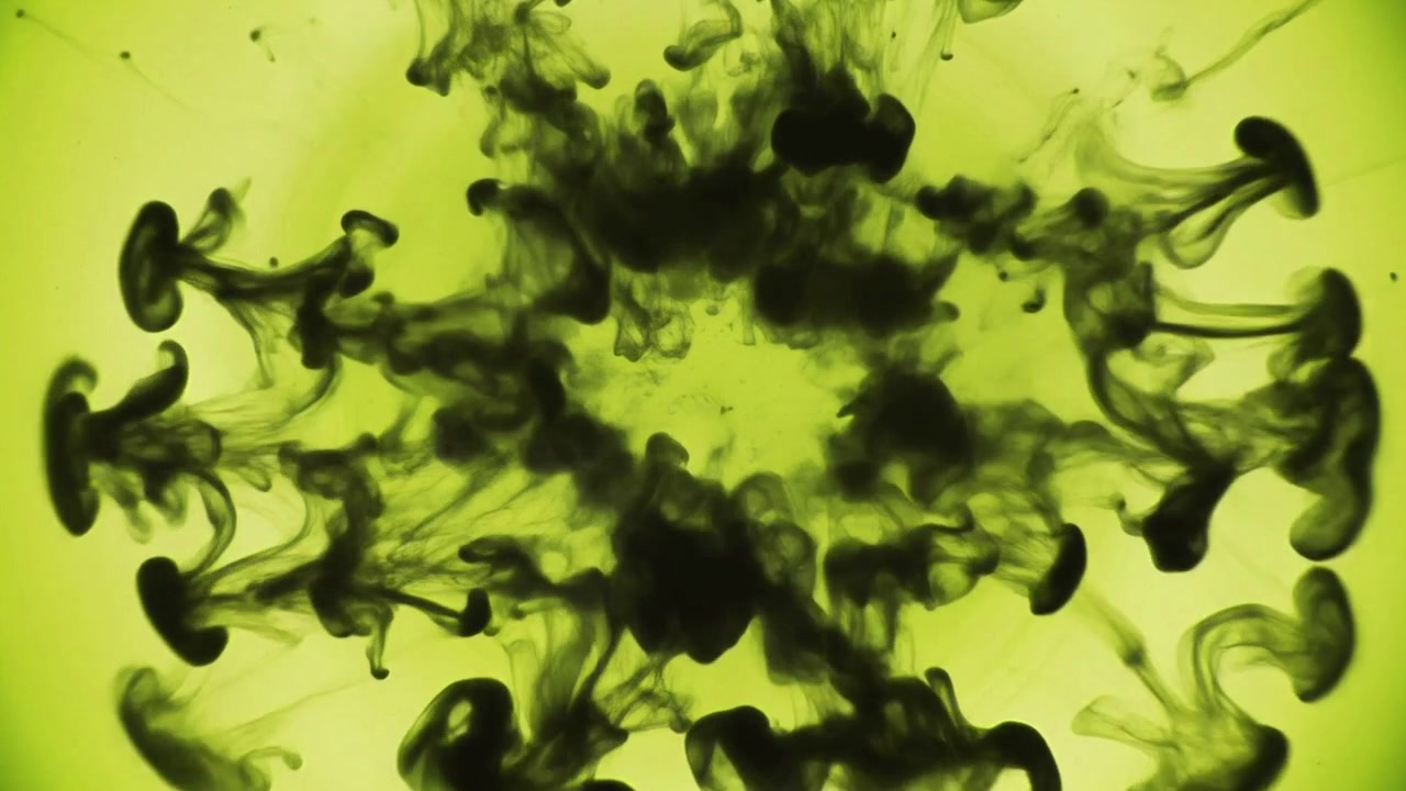 Encre noire tombant et se propageant dans un liquide vert éclatant