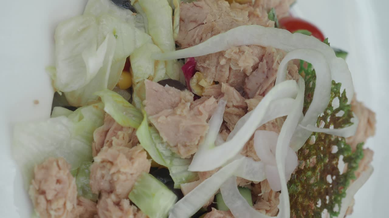 Close-up of a Fresh Tuna Salad with Greens and Onions