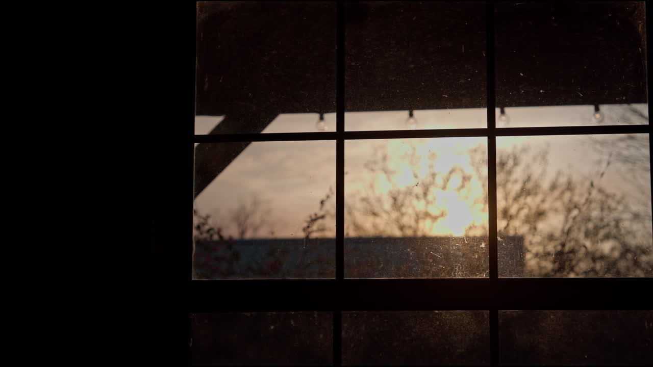 Old rustic window in the evening with the sunset peeking through