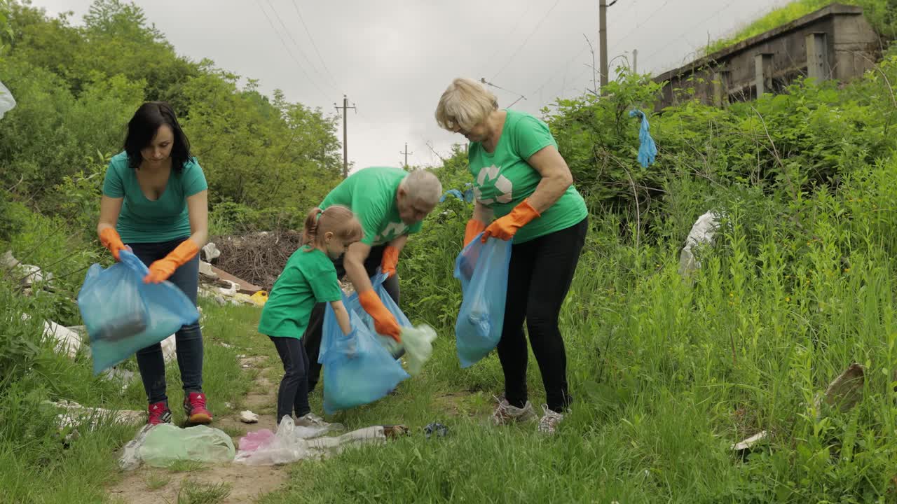 equipo de activistas de la naturaleza con camisetas ecológicas recogiendo basura plástica en el parque. reciclaje, contaminación de la tierra