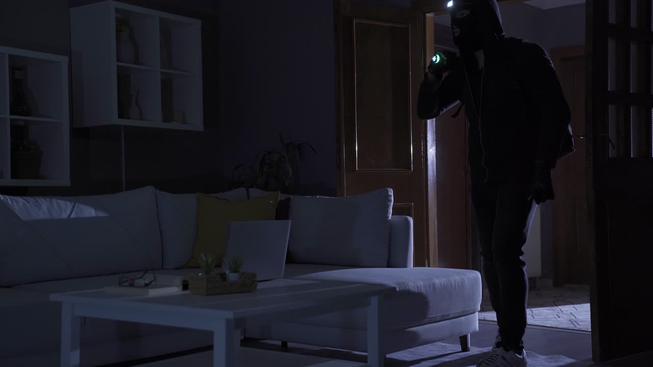 ladrón hombre robo en casa con linterna.