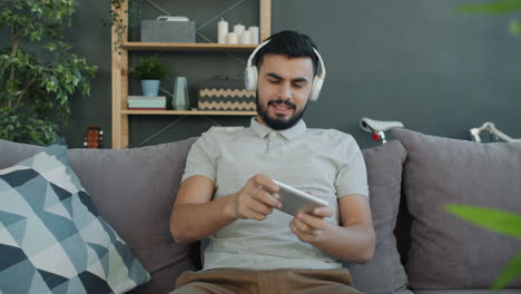 Man playing mobile game on couch