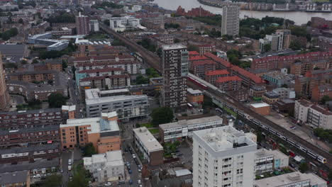 Dia-Und-Schwenk-über-Die-Stadtentwicklung.-Luftbild-Von-Zügen-Auf-Der-Bahnlinie-In-Der-Stadt.-Wolkenkratzer-Im-Modernen-Geschäftsviertel-Im-Hintergrund.-London,-Vereinigtes-Königreich