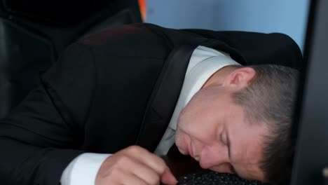Tired businessman sleeping on keyboard