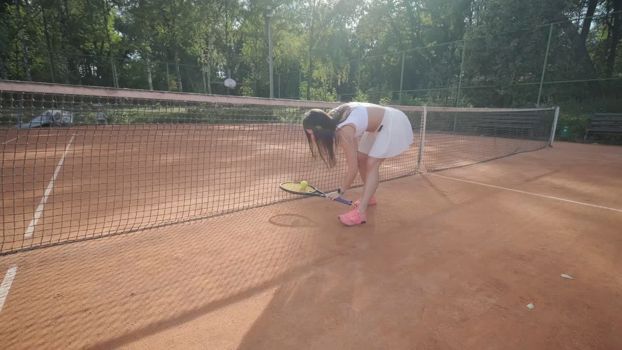 여자 테니스 선수 가 야외 코트 에서 세브 를 연습 하고 있다