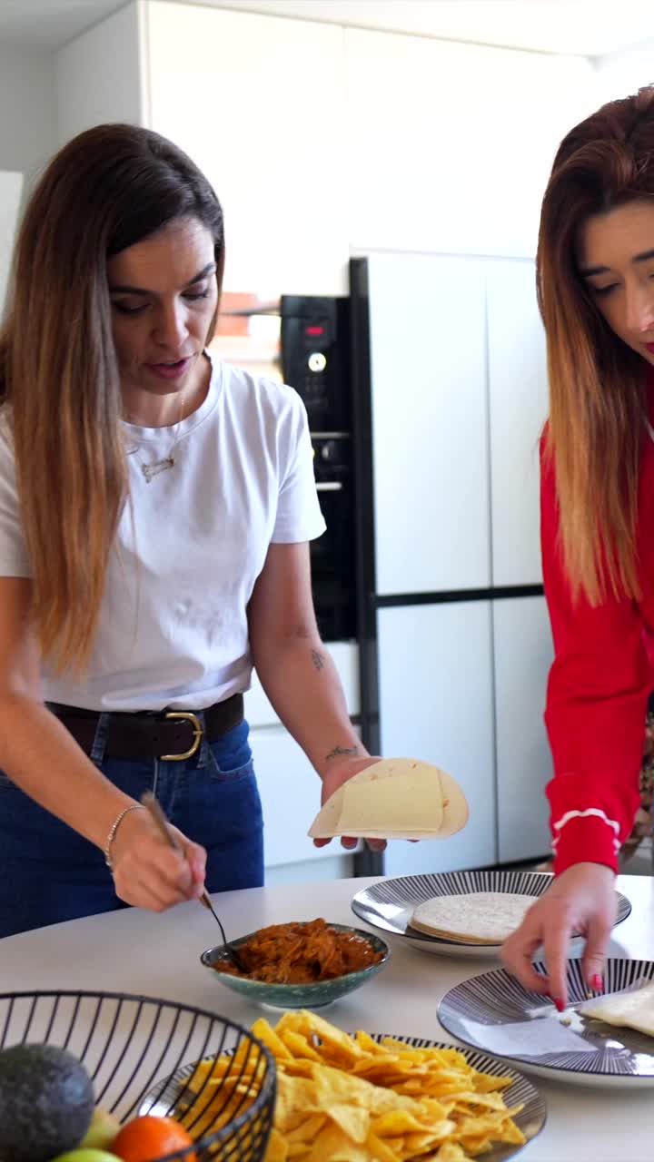 Women preparing tacos in kitchen