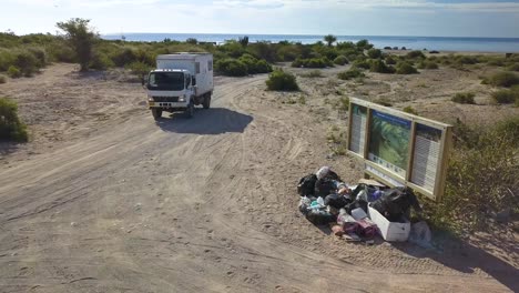 environmental cleanup truck cleaning beaches in baja, mexico - aerial drone tracking view