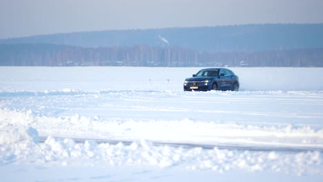 blue suv driving on frozen lake in winter