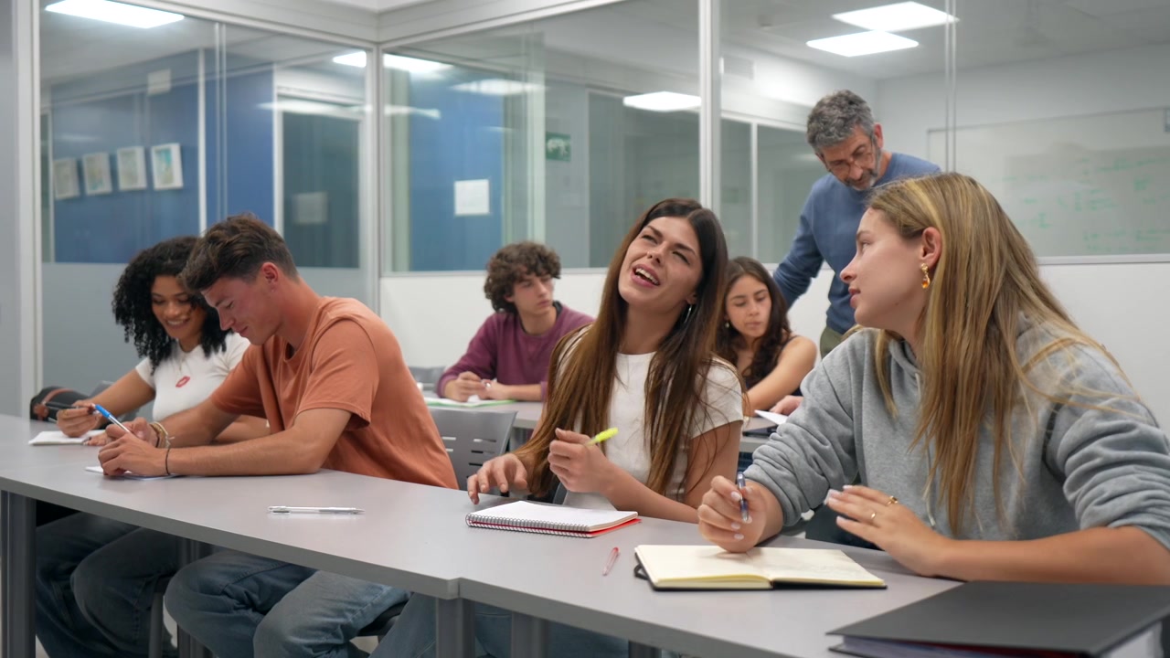 Young Students Writing and Discussing in a Modern University Classroom