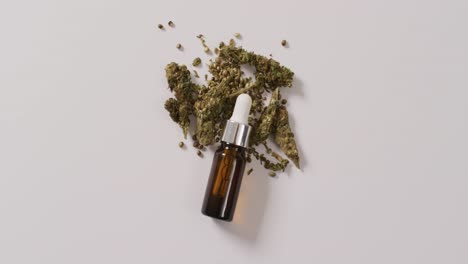 Video-of-marijuana-buds-and-bottle-of-cbd-extract-on-white-background