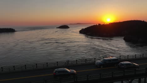 long aerial shot starting of the sunset over the san juan islands and pulling back to reveal the deception pass bridge