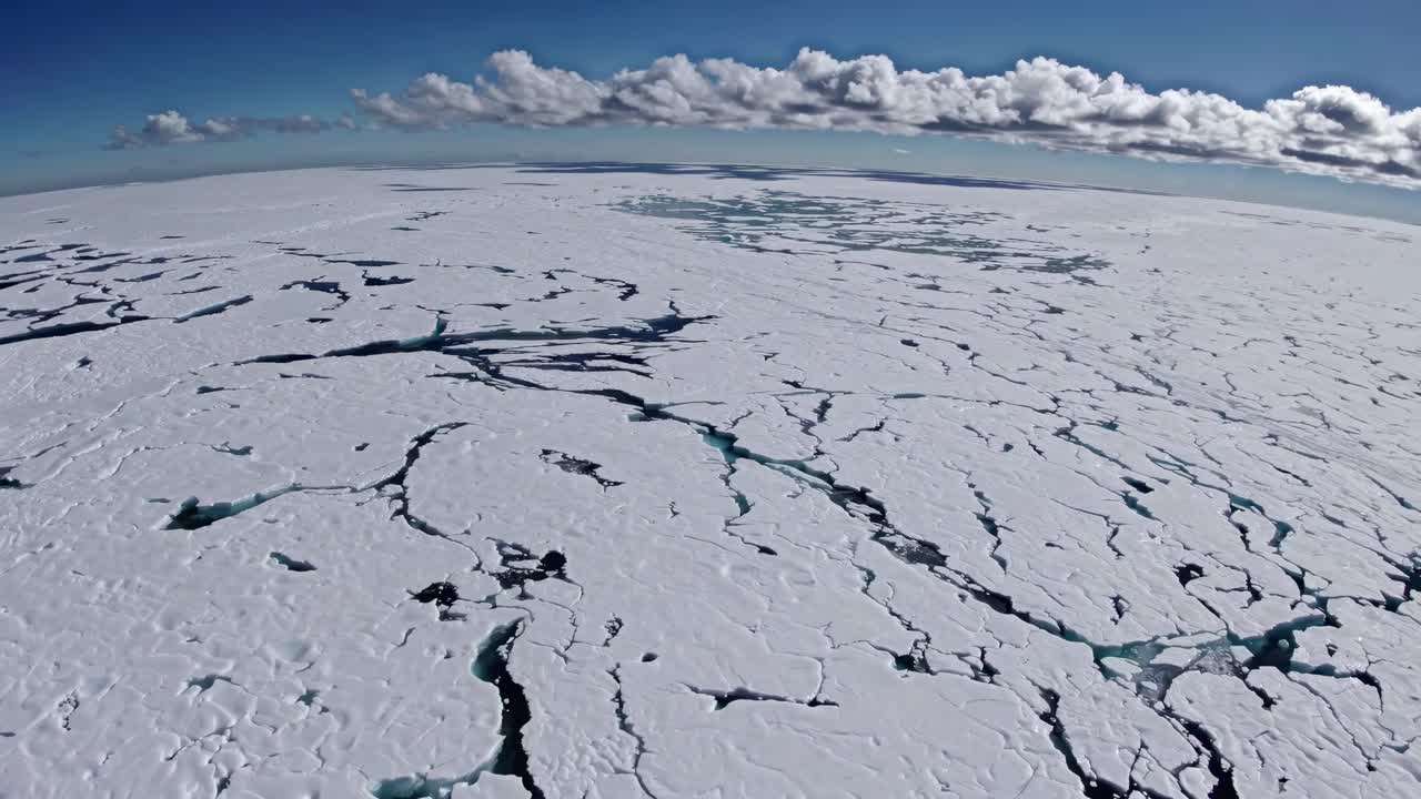 Aerial video captures cracked ice sheets on a frozen sea, showcasing nature's patterns from a high