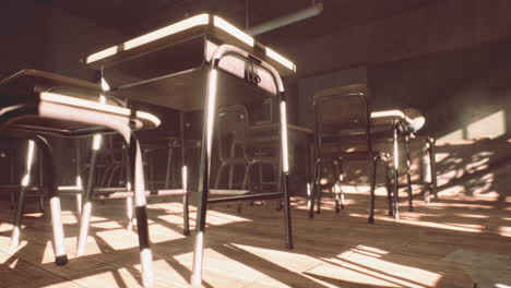 view to classroom with tables and small blackboard and grungy walls