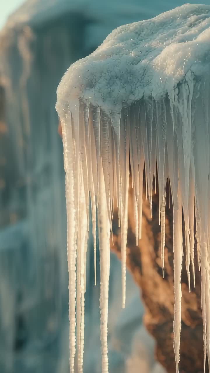 Vídeo vertical: luz do sol se movendo sobre a borda nevada, aquecendo estalactites que balançam e derretem a água