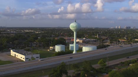 establishing drone shot of alief area in houston featuring water tank and tollway