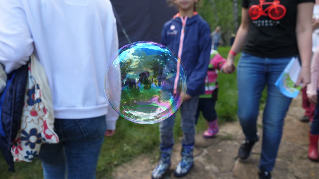 공원 에서 비누 거품 을 가지고 놀고 있는 아이 들