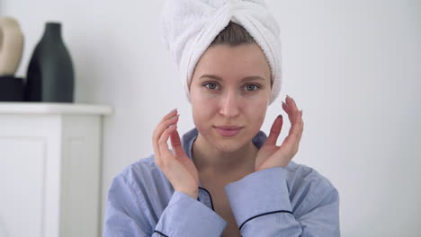 portrait of young female applying moisturizer