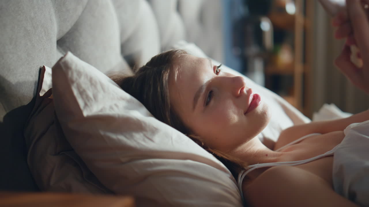 스마트폰을 사용하는 침대에 있는 여자