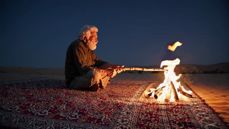 elderly man by a campfire in the desert at night