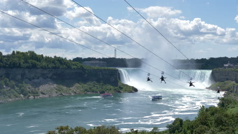 zip line riders descending down by the niagara falls, summer adventure