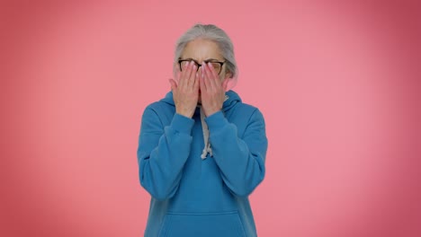 anciana abuela anciana cerrando los ojos con la mano mostrando el gesto de parada, confundida tímida asustada de ver
