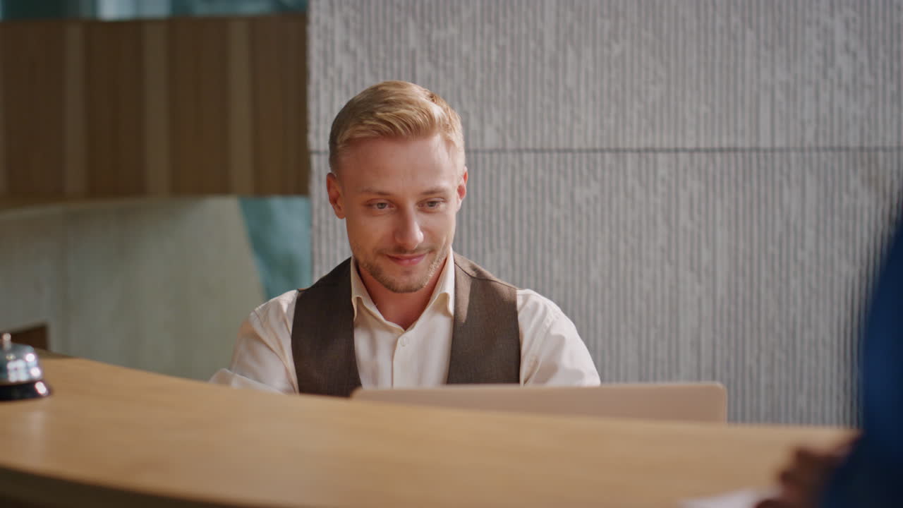 el conserje del hotel chequeando documentos en el escritorio. hombre sonriente conociendo a los huéspedes.