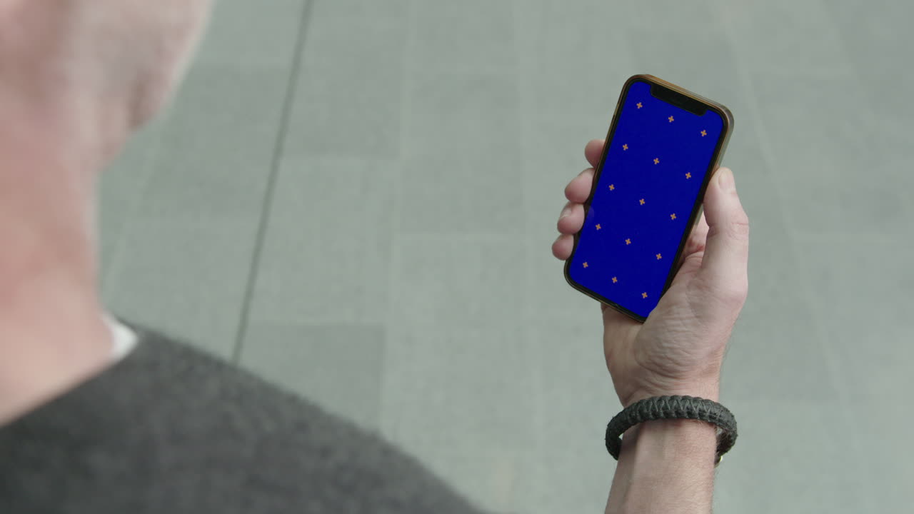 스마트폰을 들고 있는 사업가가 앱 스토어 ios 핸드폰 블루 그린 스크린 교체 추적 마커 시각 효과 vfx 키잉 삼성 틱톡 추세 사람 주식을 부르는 숫자를 보고 있습니다.