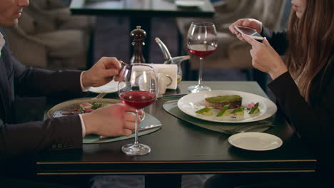 Business-woman-photographing-food-on-smartphone-at-restaurant