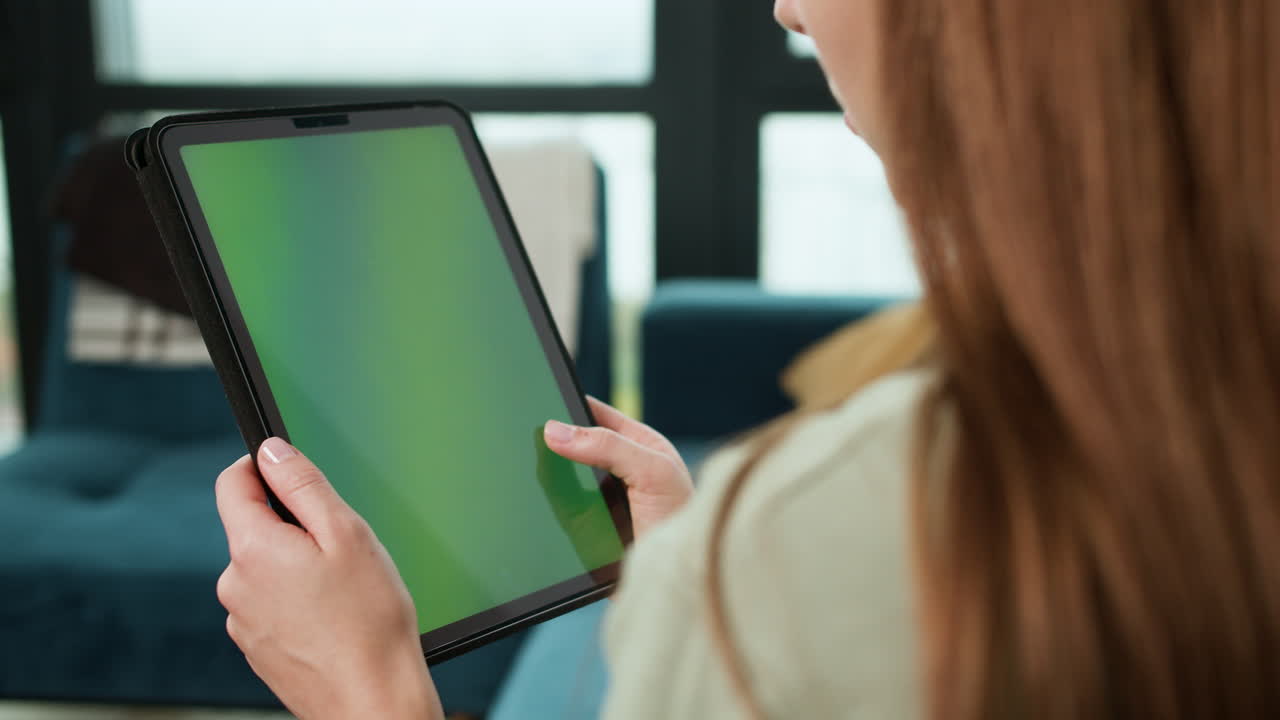 집에서 태블릿을 스크롤하는 여자