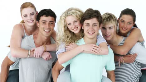 male teenagers giving their friends piggyback rides