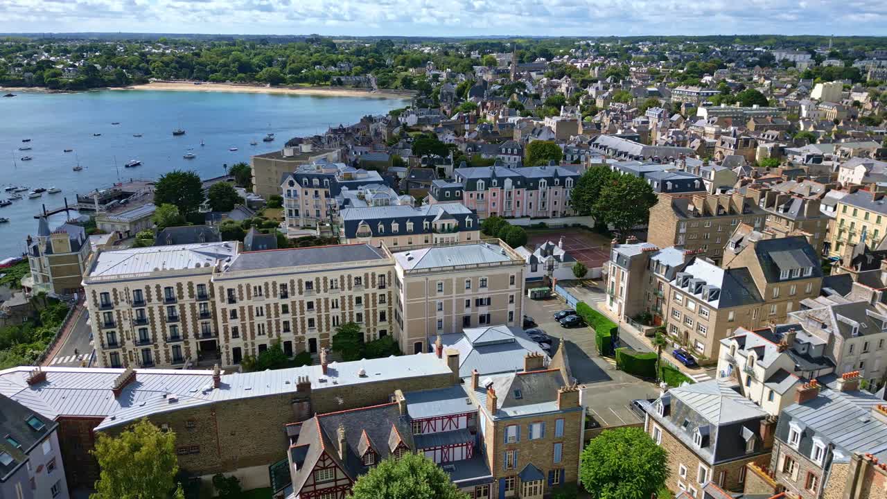 Panning panoramic drone fly over the seaside Dinard commune with historic waterfront buildings and boats in harbor, Ille-et-Vilaine, France