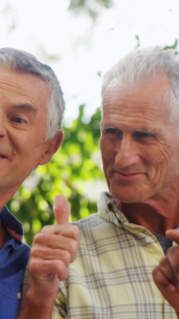 Animation of falling icons over diverse group of senior men using smartphone