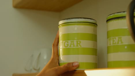 close up of woman putting a sugar jar on a shelf 4k