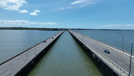 Drone-establishing-tracking-shot-of-Ted-Smout-Memorial-Bridge,-camera-flying-in-between-both-bridge-lanes,-following-cars-as-they-drive-across-the-bridge