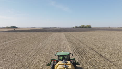 Tractor-Pulling-Strip-Till-Machine-to-Prepare-for-Seeding,-Aerial