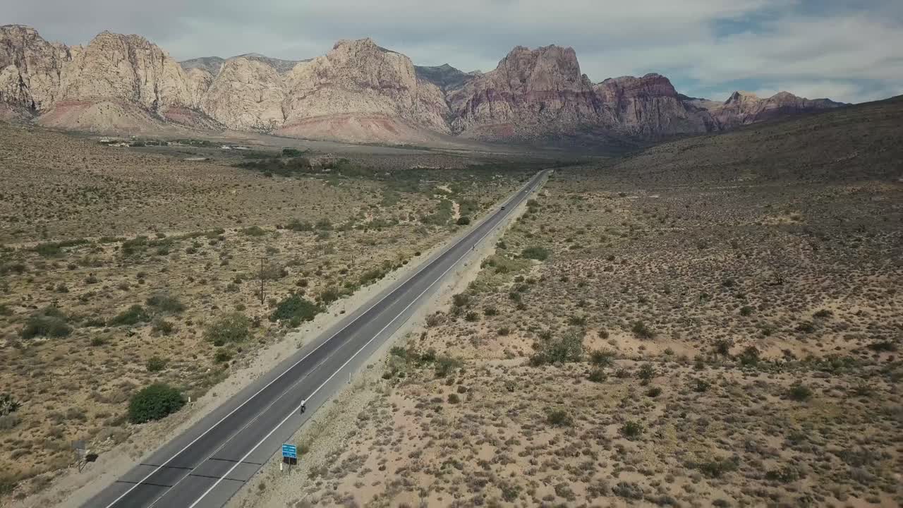 volando por una carretera en el desierto de nevada con montañas al fondo